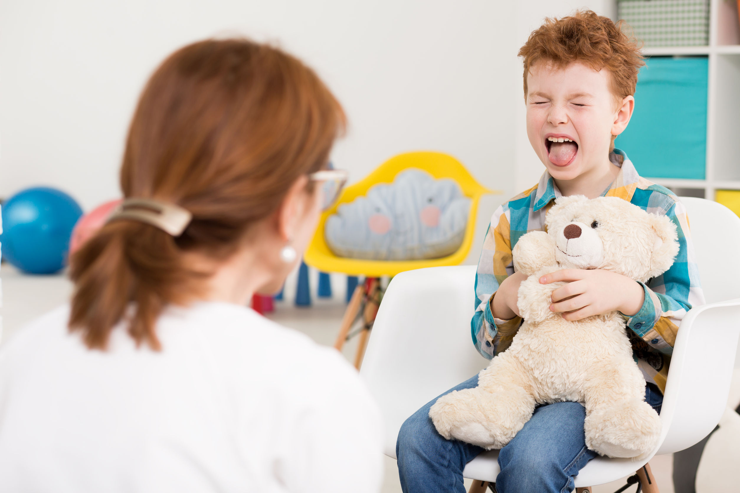 naughty young boy with adhd screaming at psychologist's office