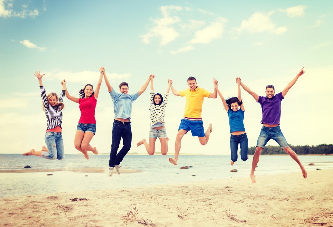 summer-holidays-vacation-happy-people-concept-group-of-friends-jumping-on-the-beach
